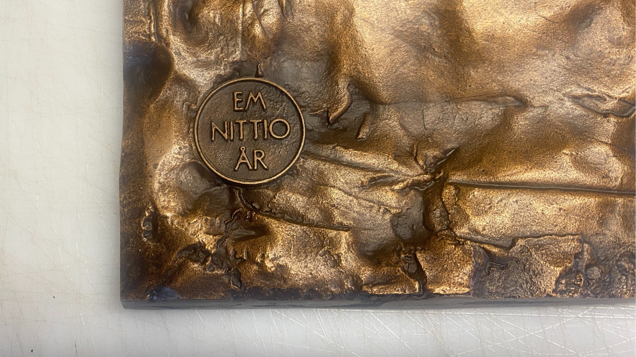 Akompani bronsskylt case sidan